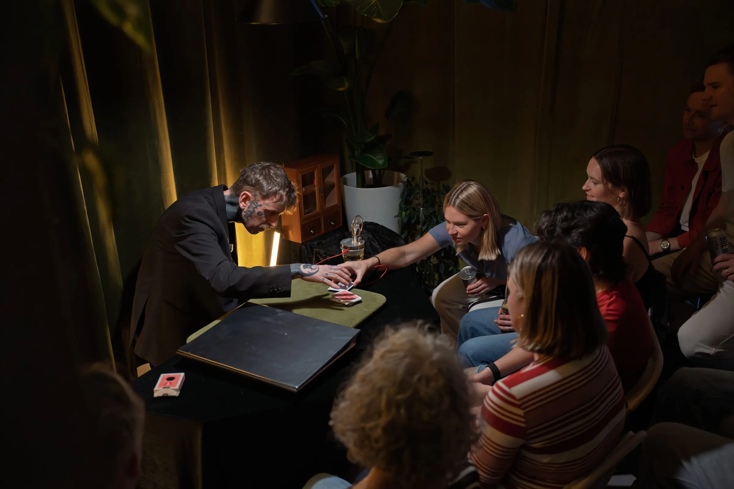 A guest reaching in to touch the cards as Si performs across the table