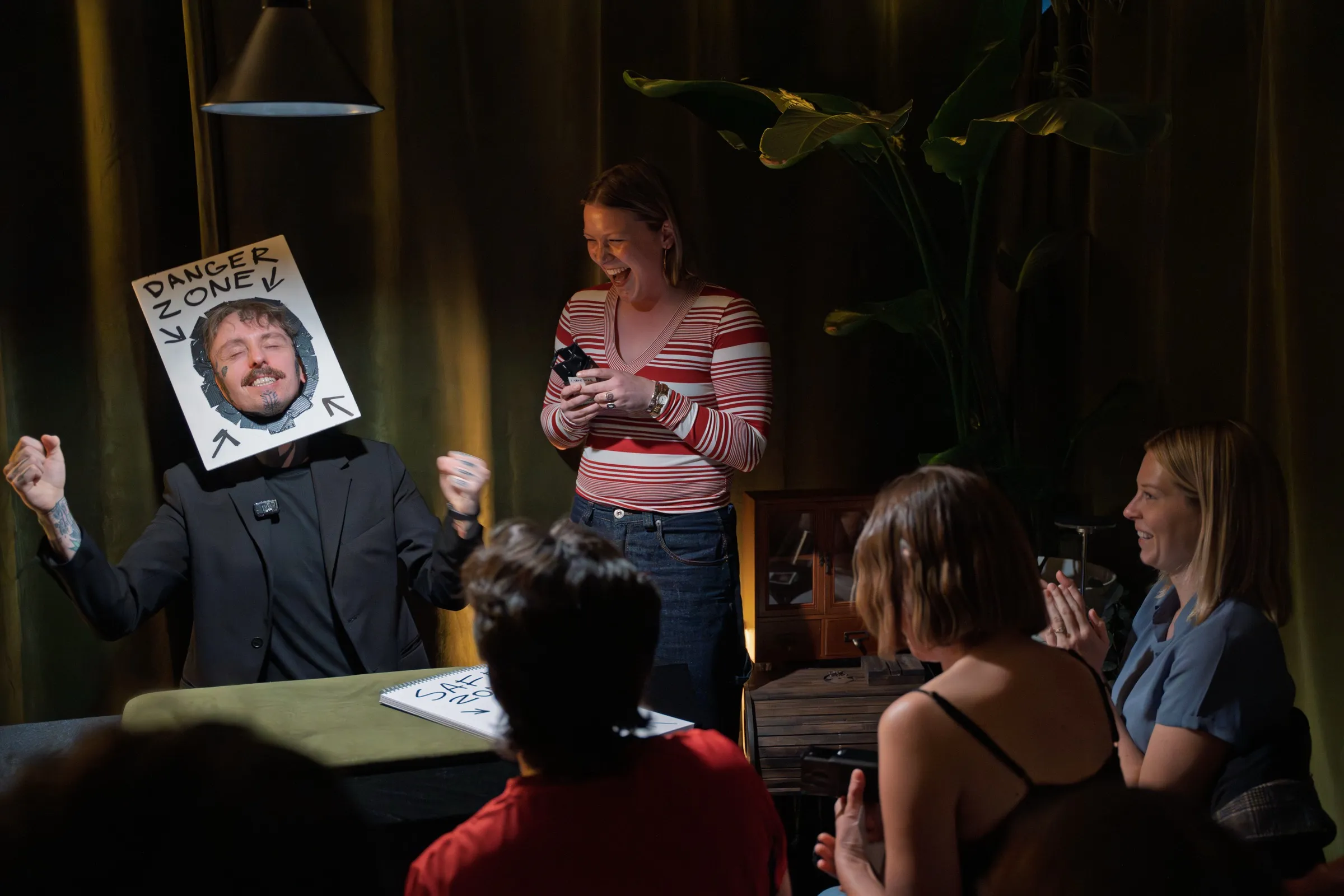 A delighted guest cheering during a playful “danger zone” routine at a Bristol Magic Theatre show